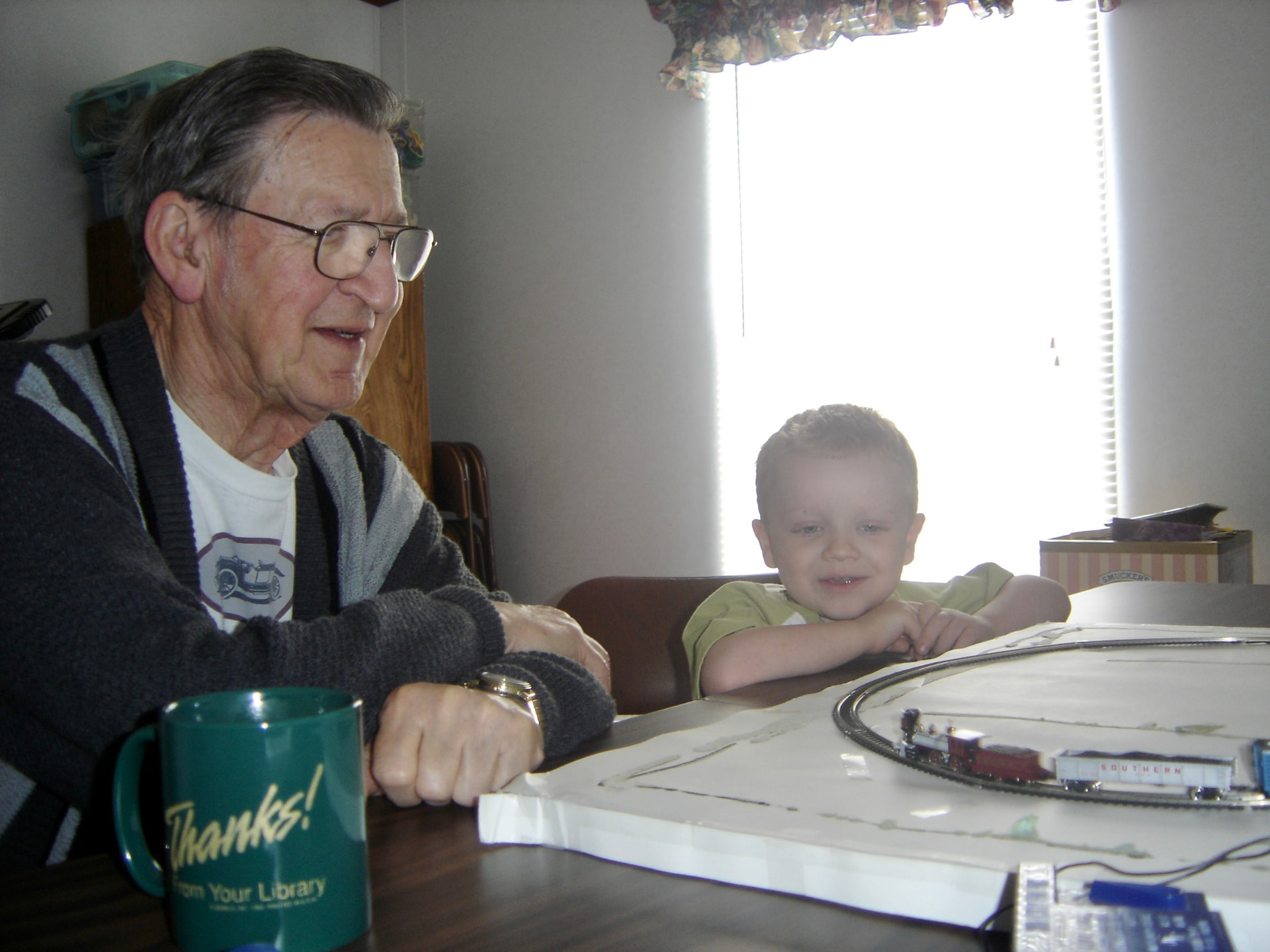 Grandpa sharing his model train set with his grandson Ben