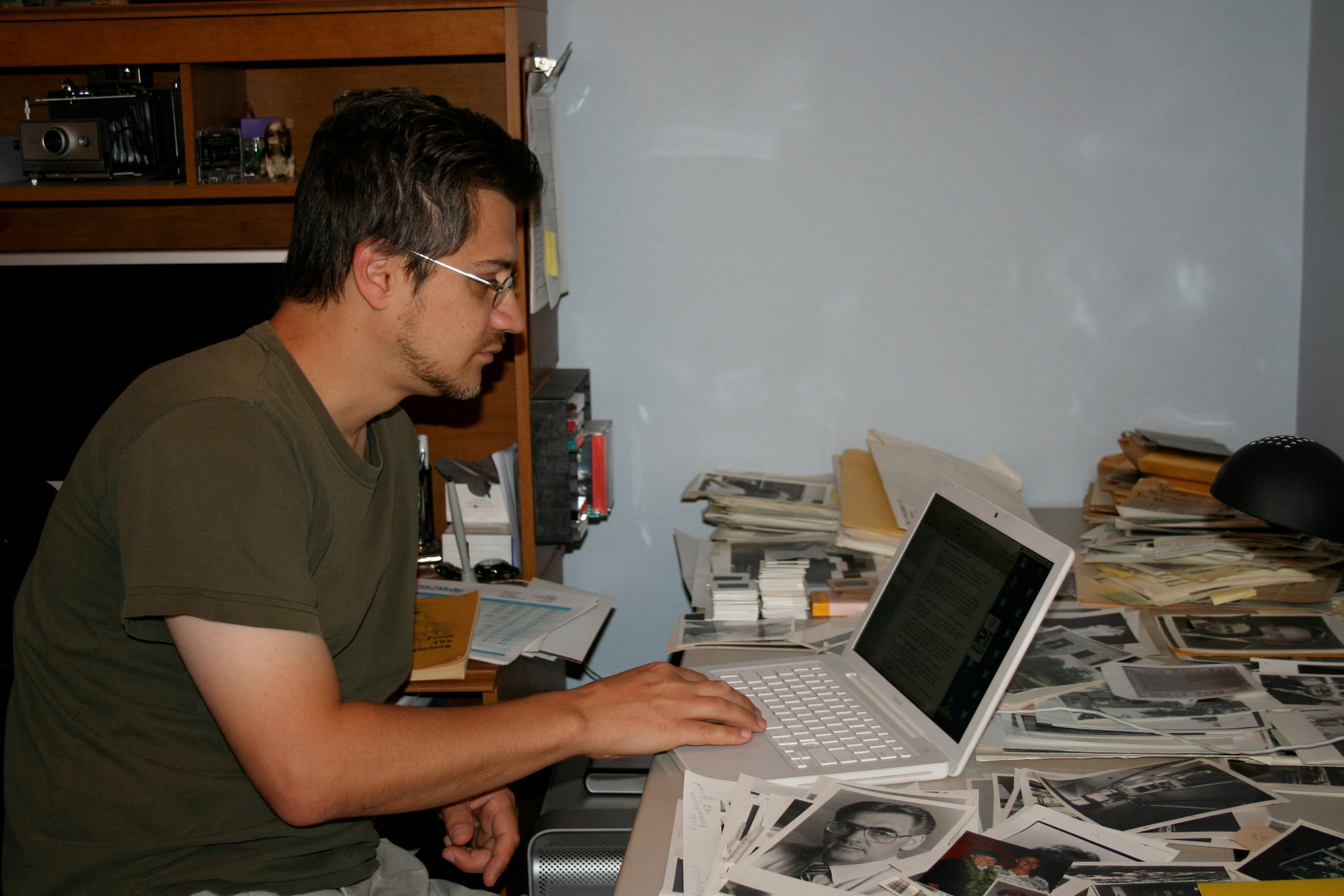 Tim Ristow at his laptop surrounded by archival Concordia photos